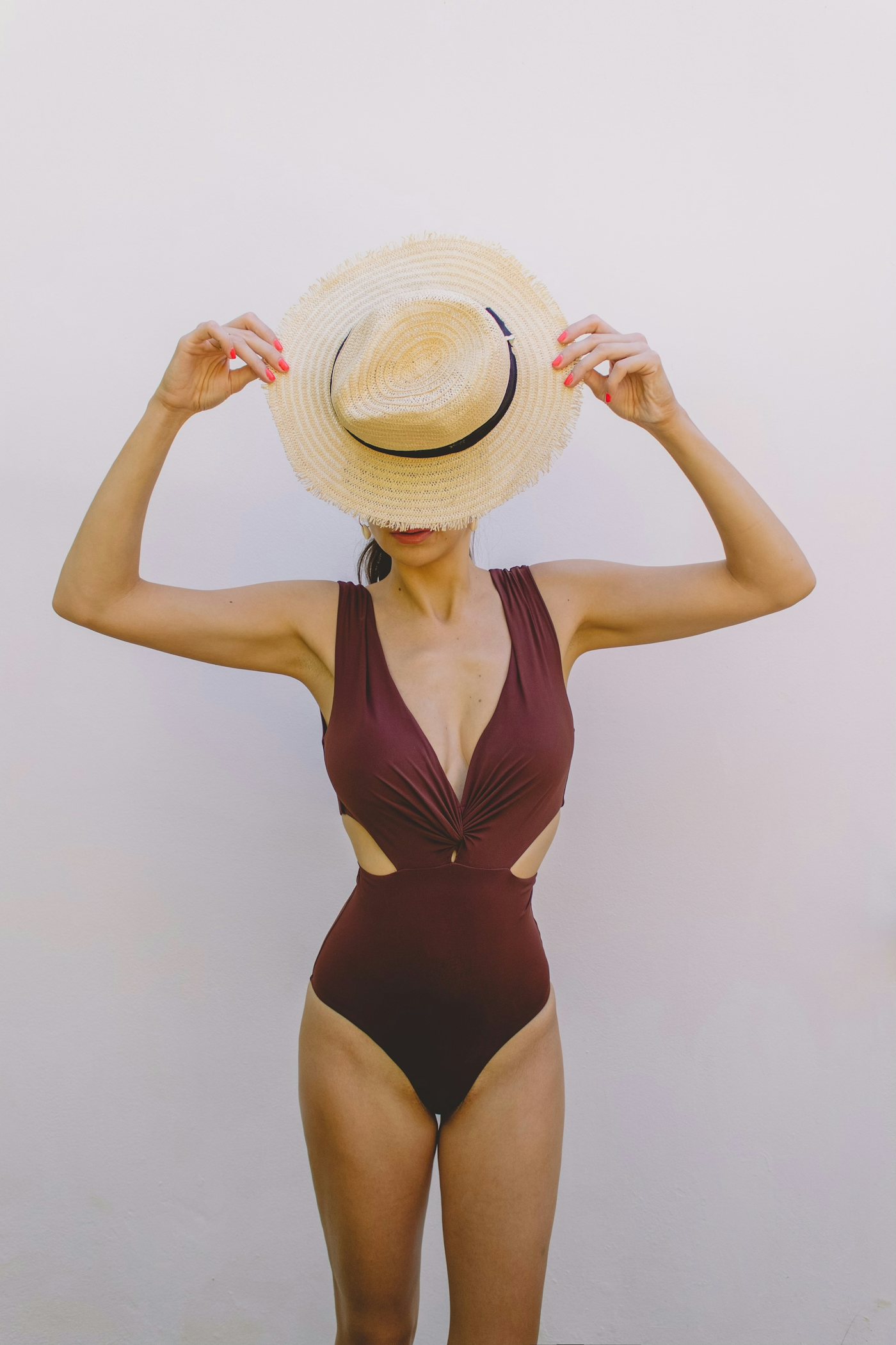 A woman in a resort swimsuit and sun hat