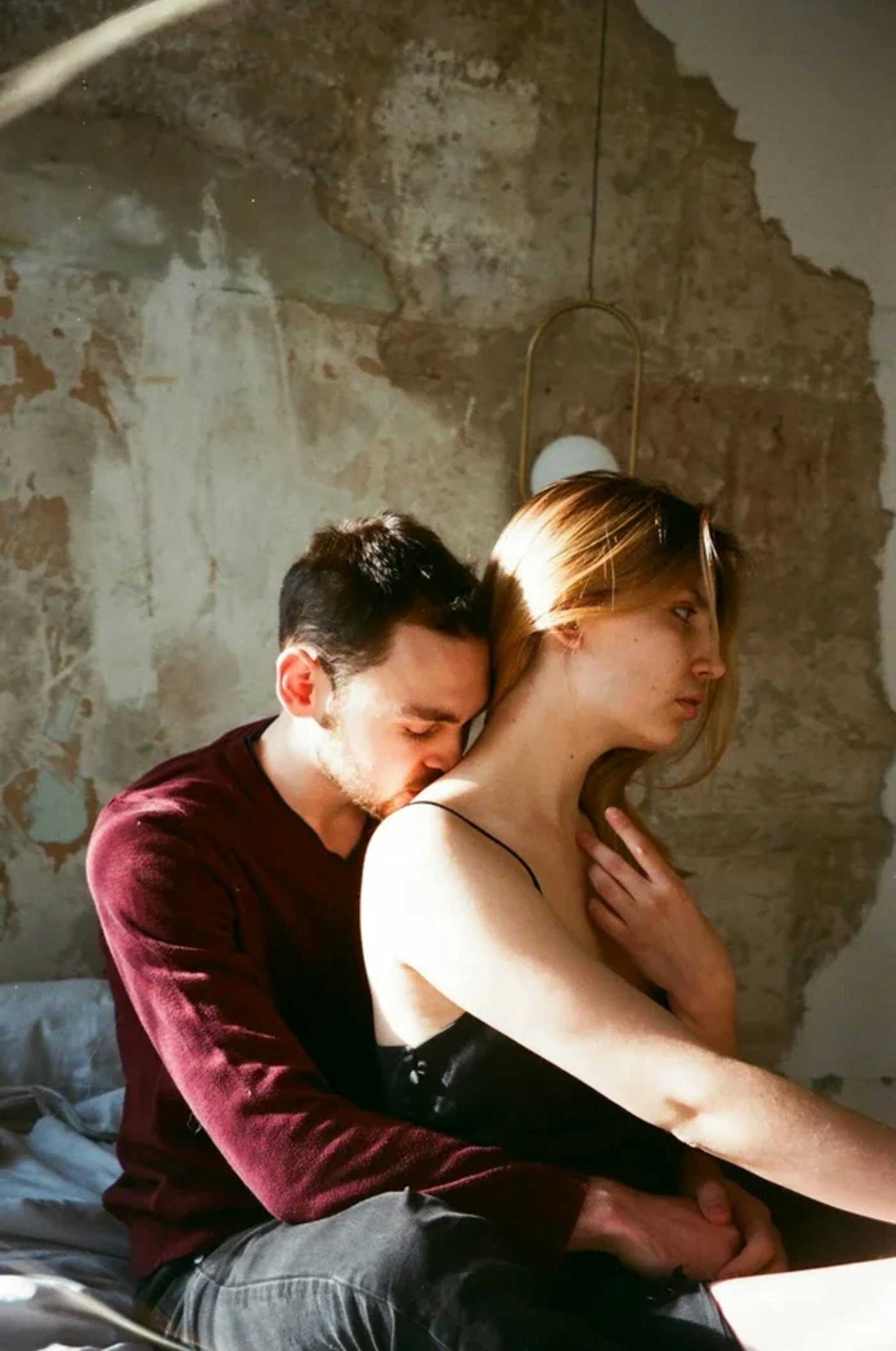 A couple embracing in a sunlit bedroom