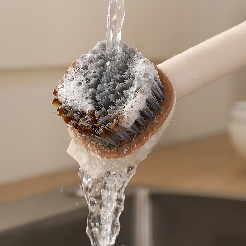 Pot cleaning brush next to sparkling clean cookware