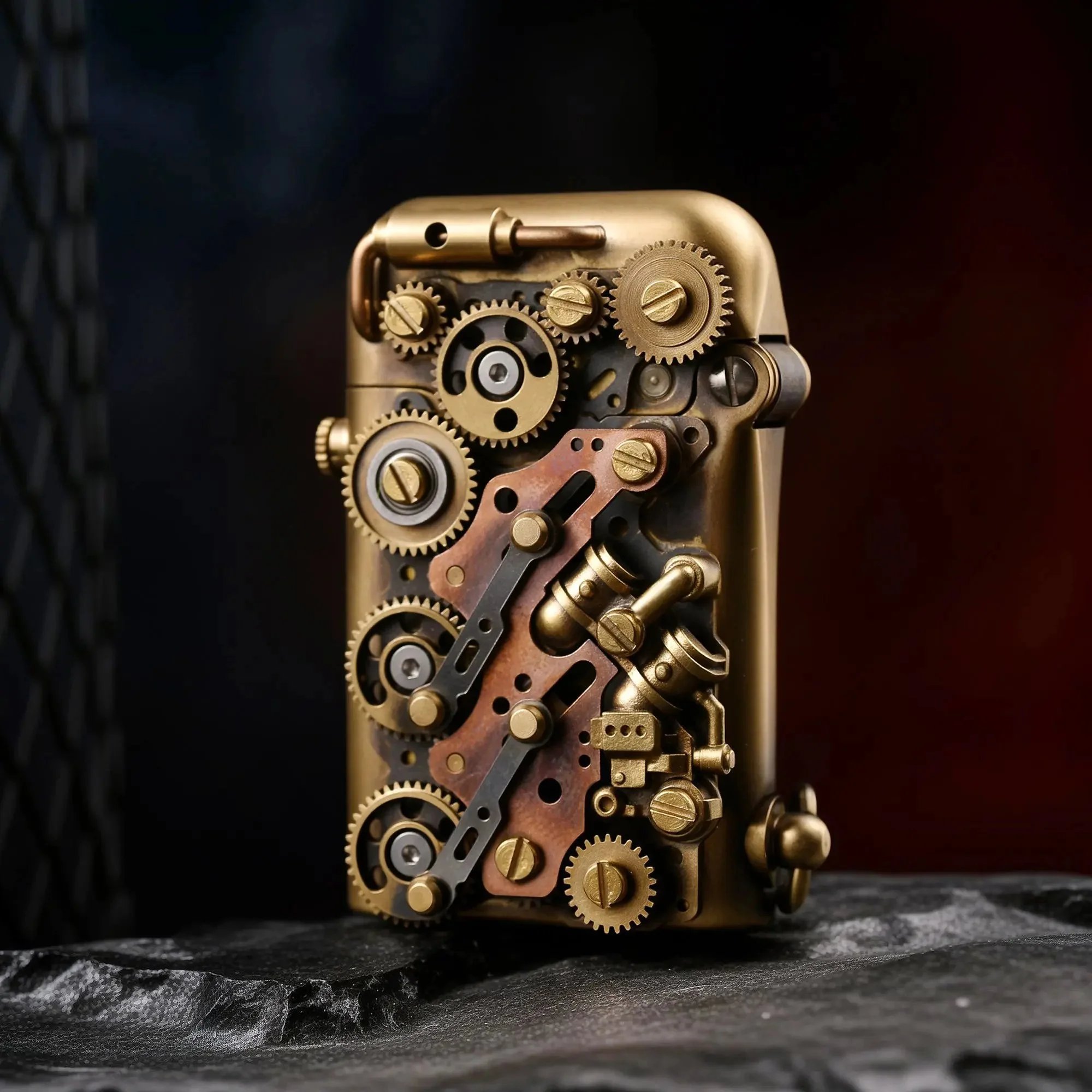 A Thorens Steampunk-Twin Torque side-fill lighter featuring a complex array of mechanical gears and copper accents on an aged brass body, resting on a dark stone surface.