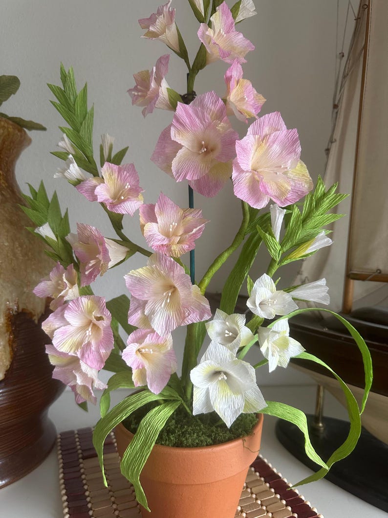 Arrangement de glaïeuls en papier crêpe fait main dans un pot en terre cuite