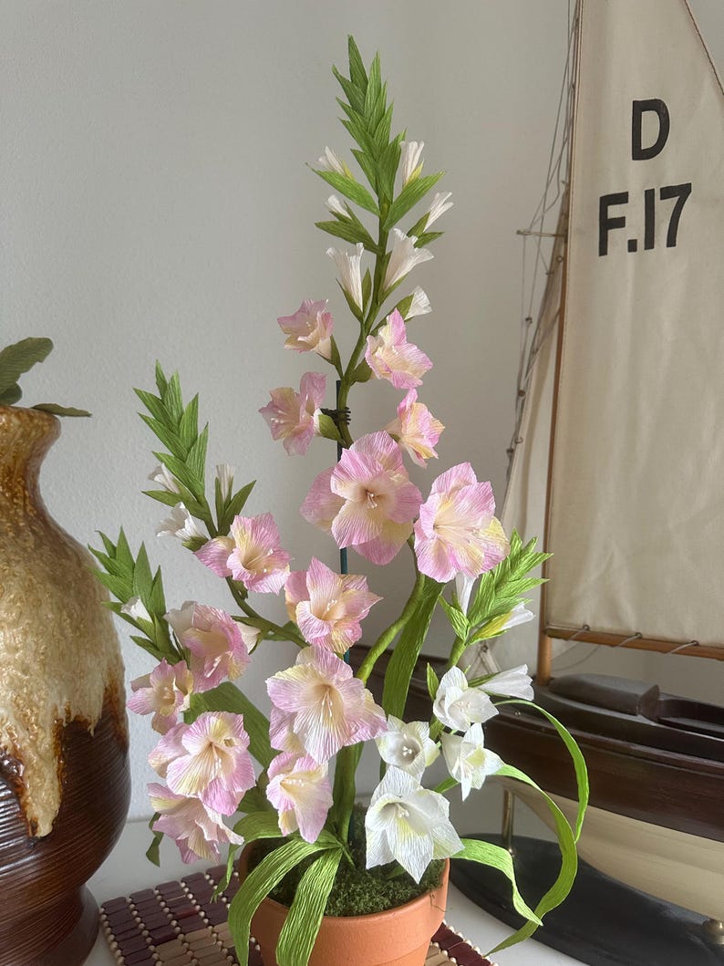 Arrangement de glaïeuls en papier crêpe fait main dans un pot en terre cuite