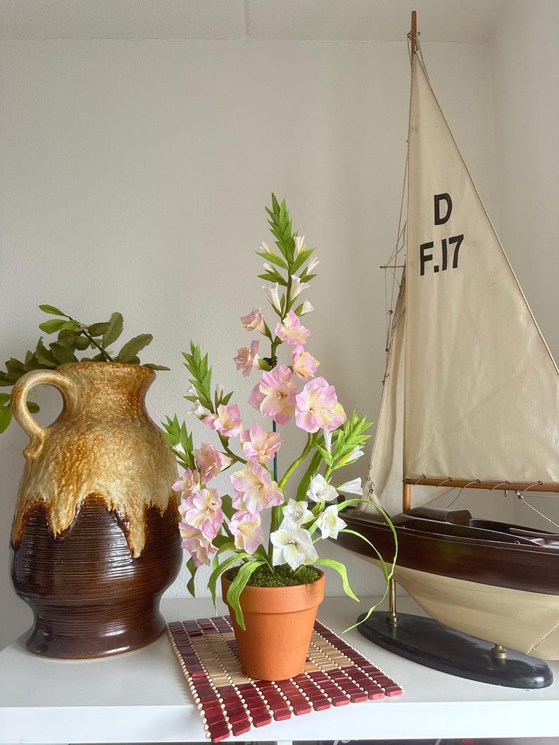 Arrangement de glaïeuls en papier crêpe fait main dans un pot en terre cuite