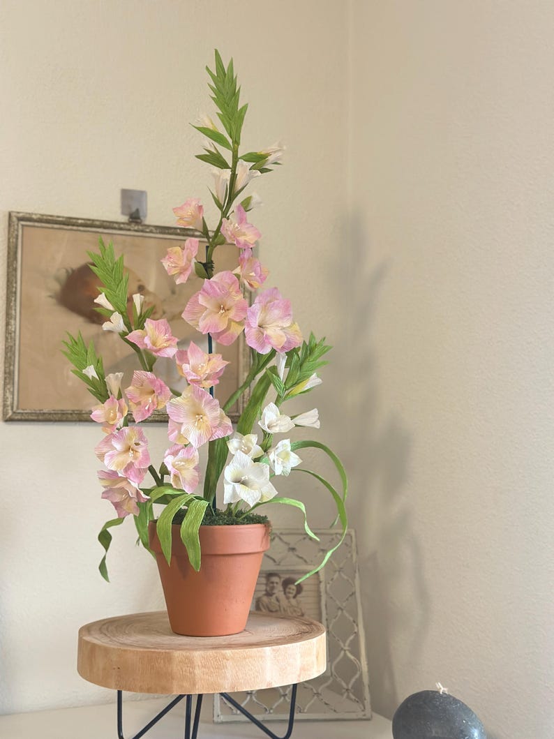 Arrangement de glaïeuls en papier crêpe fait main dans un pot en terre cuite