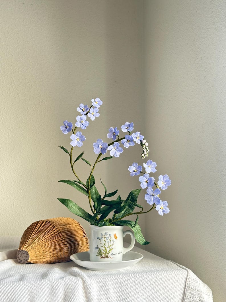 Myosotis bleus fleurs en papier crépon dans une tasse à thé