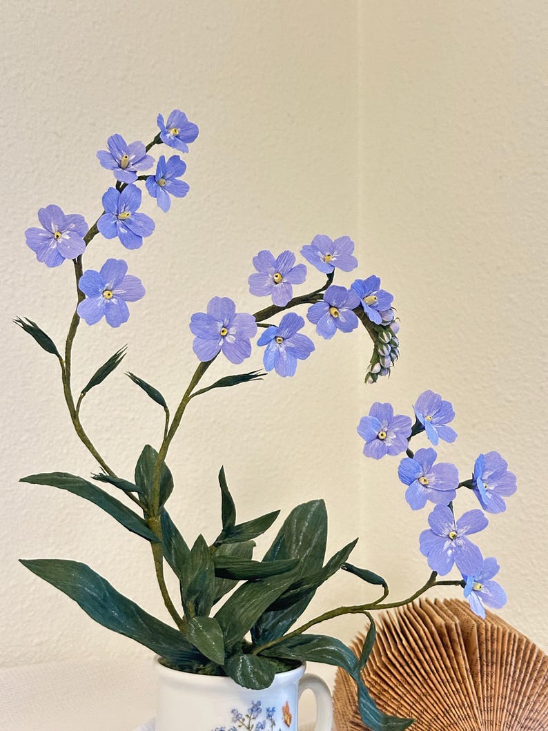 Myosotis bleus fleurs en papier crépon dans une tasse à thé