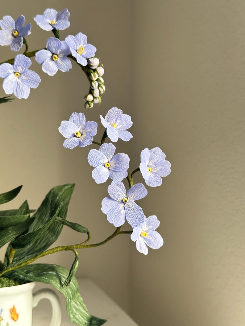 Myosotis bleus fleurs en papier crépon dans une tasse à thé