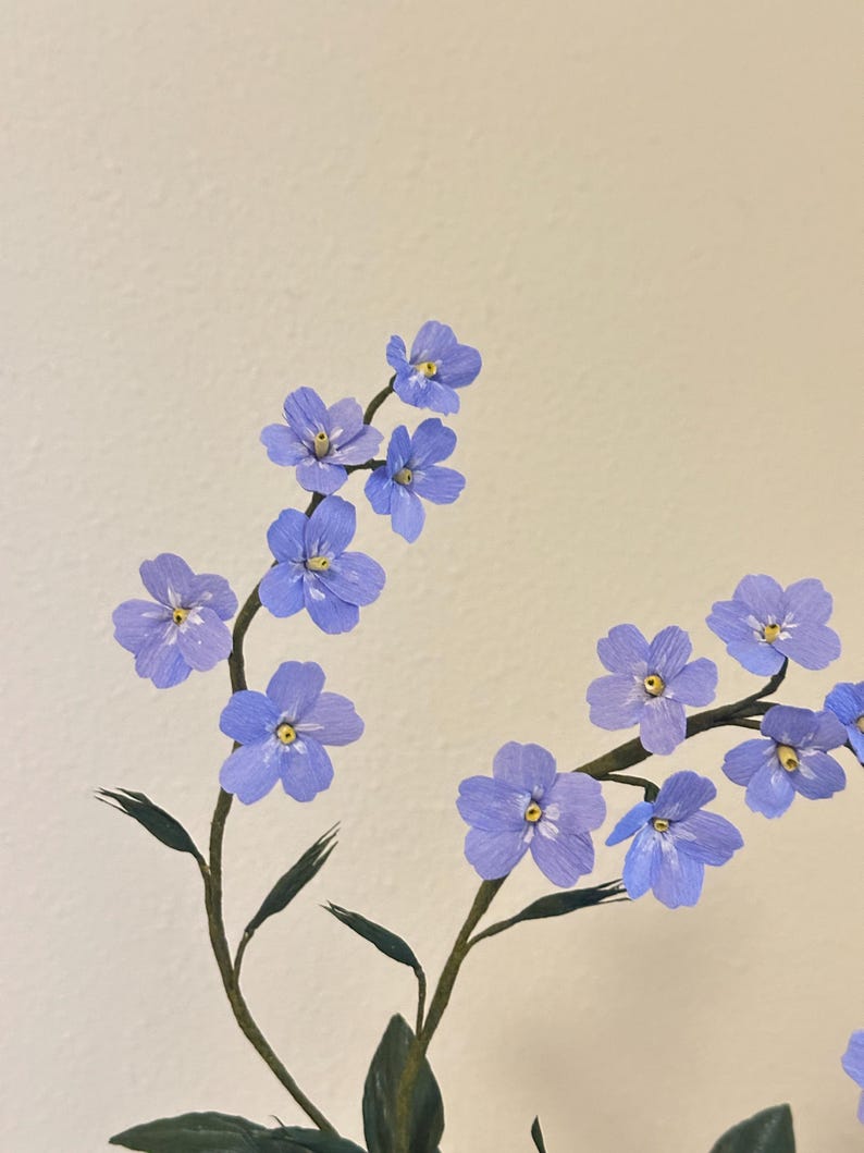 Myosotis bleus fleurs en papier crépon dans une tasse à thé