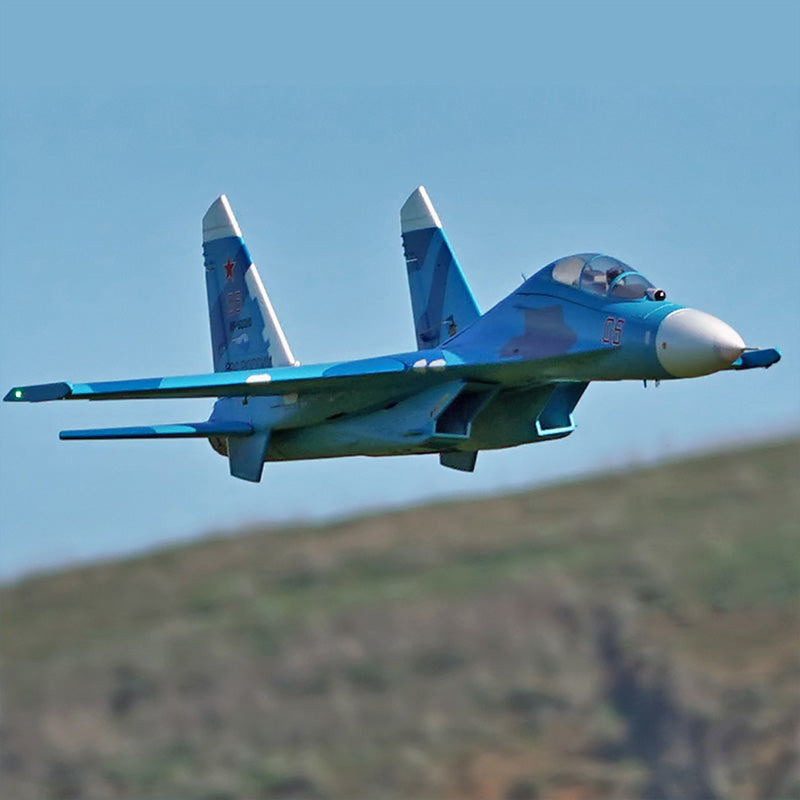 FMS Twin 70mm EDF SU-27 PNP model airplane in blue camouflage, flying in the sky.