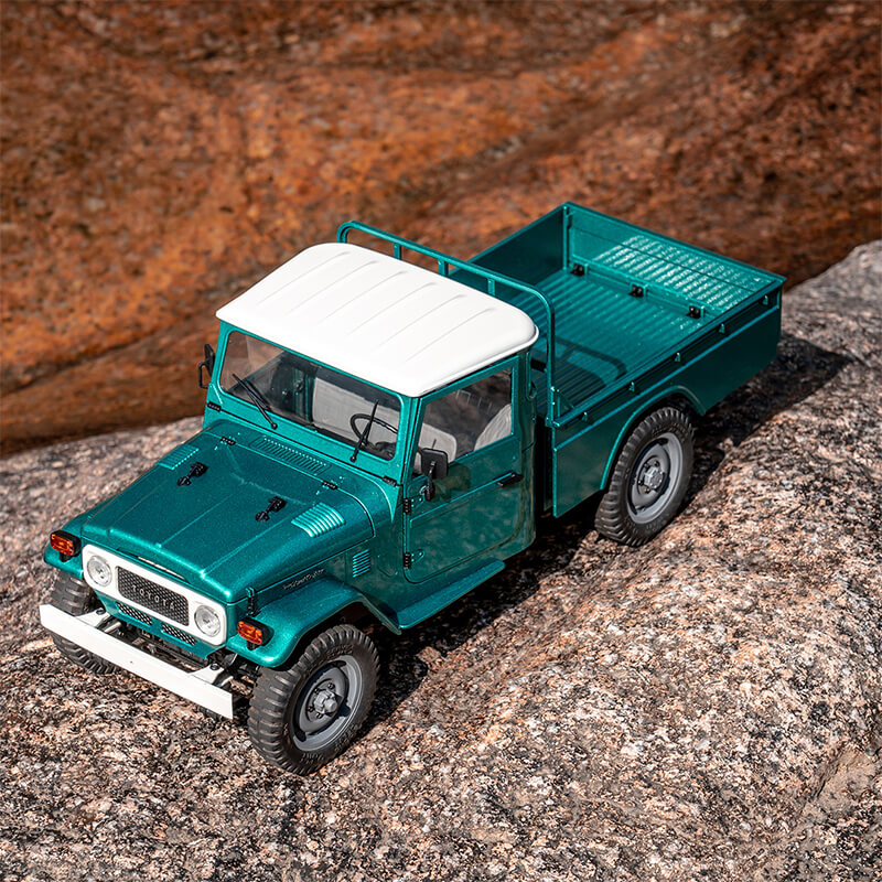 FMS 1:12 teal Toyota FJ45 pickup truck RC with white roof on rocks