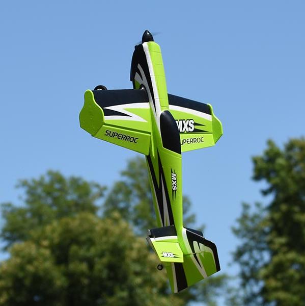 FMS 1100mm MXS V2 PNP green aerobatic RC plane in flight with black accents.