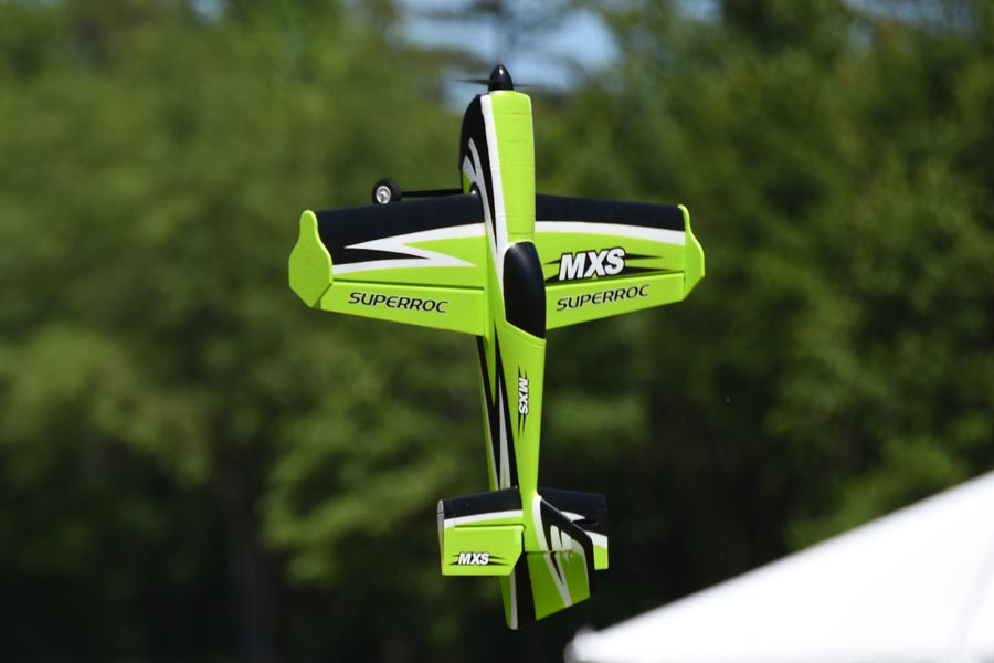 FMS 1100mm MXS V2 PNP green aerobatic RC airplane in flight with MXS branding