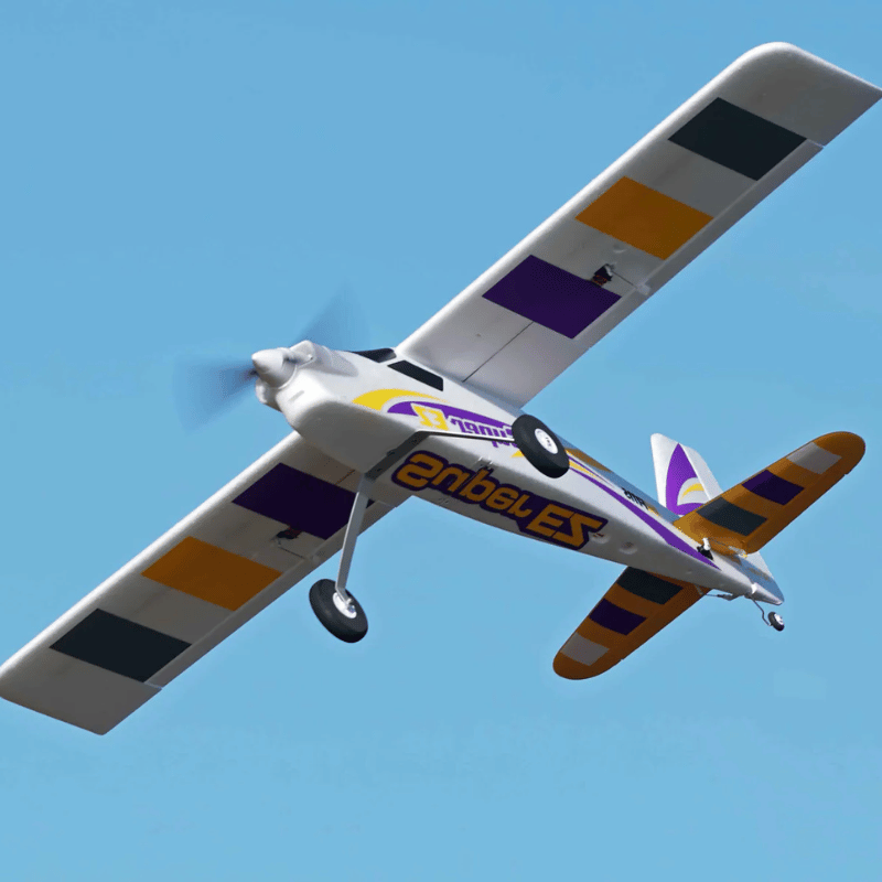 FMS 1220mm Super EZ V4 RC airplane in flight, white with purple and orange accents.