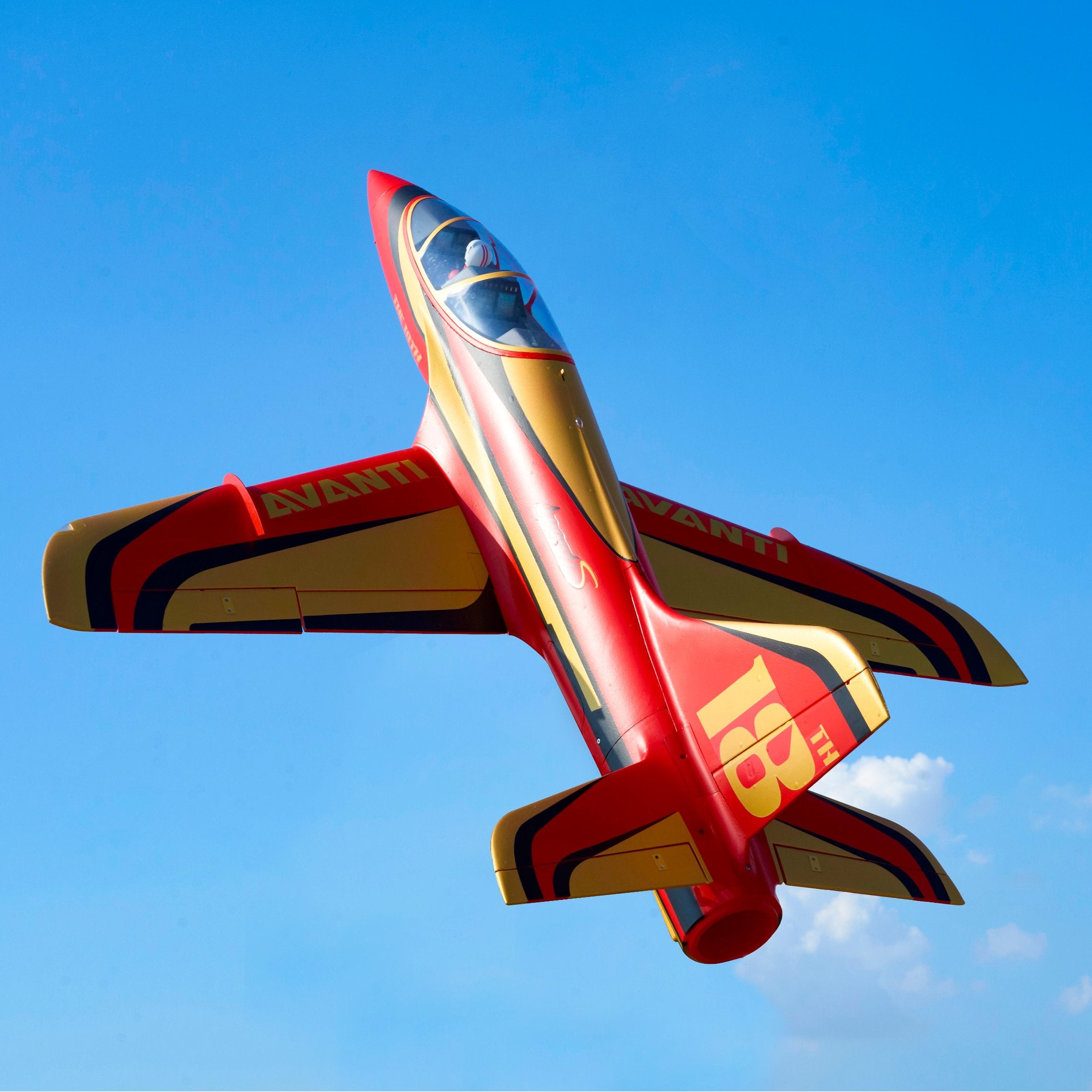 Modelo de jet acrobático a control remoto en rojo y amarillo.
