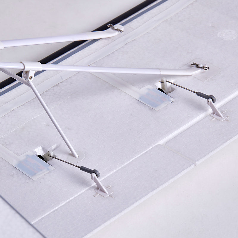 FMS 1300mm PA-18 Super Cub RC airplane wing underside with servo horns and landing gear struts.