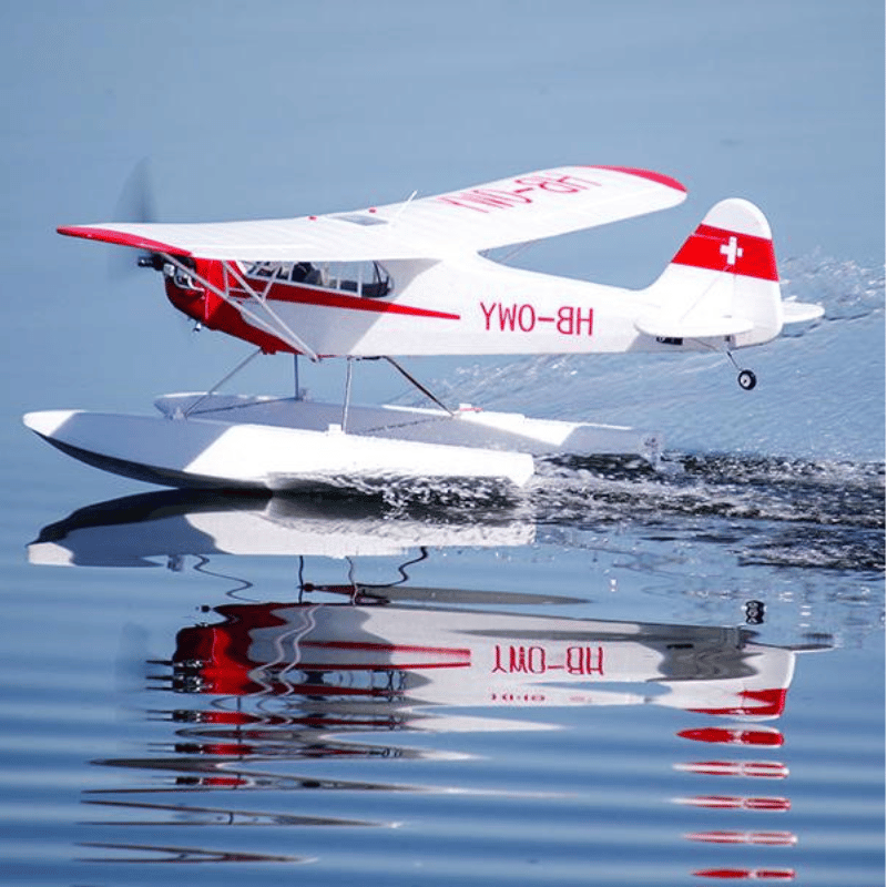 FMS J-3 Cub V4 RC seaplane flying over calm water surface