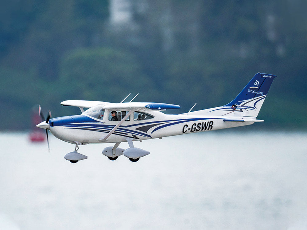 Blue and white Cessna 182 RC airplane soaring in the sky