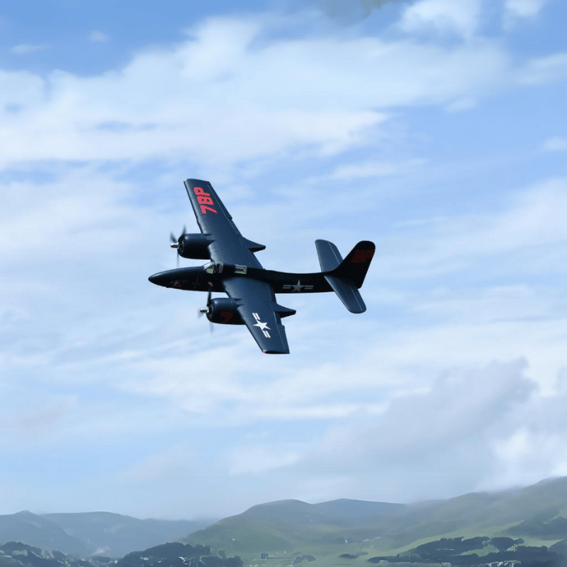 FMS 1700mm F7F Tigercat soaring in the sky above green hills