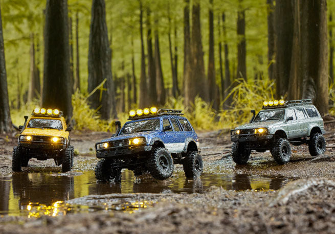 Three RC crawlers off-roading in forest