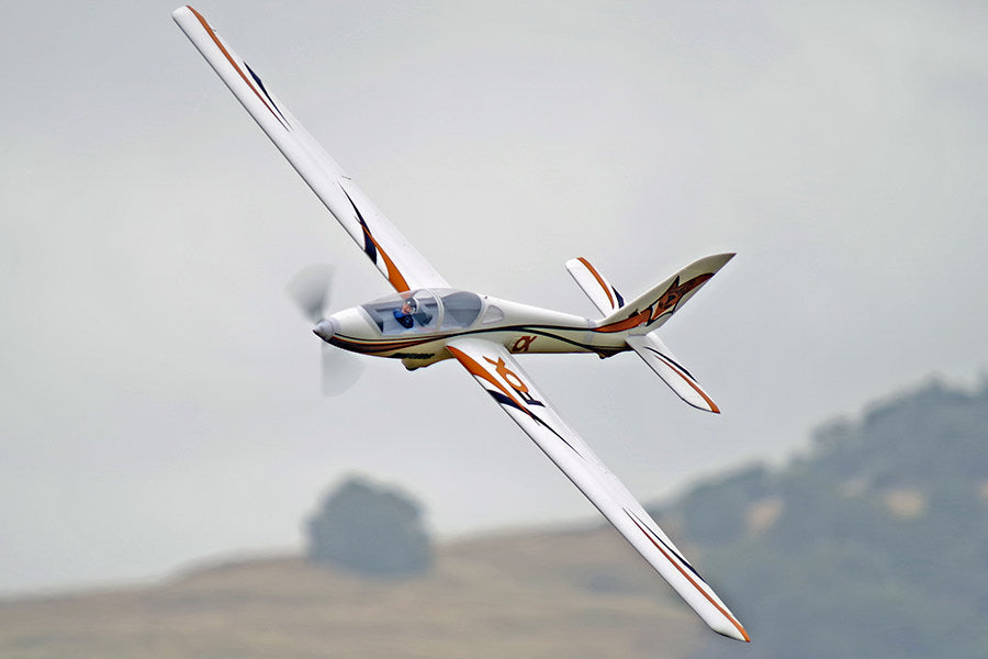FMS 3000mm Fox Aerobatic glider in flight, white with orange and blue accents, featuring the "FOX" logo.