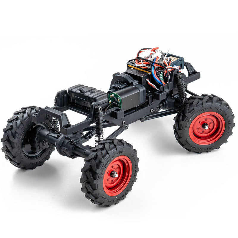 FMS 1:24 FCX24 Power Wagon chassis with red rims and all-terrain tires, showcasing its off-road crawler capabilities.