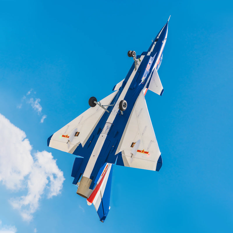 FMS J-10 EDF Jet with blue and white stripes flying against a blue sky, showing landing gear extended.