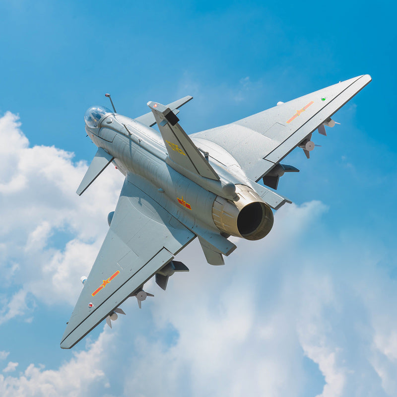 FMS EDF Jet 64mm J-10 PNP model aircraft flying in blue sky with detailed grey finish and weaponry.
