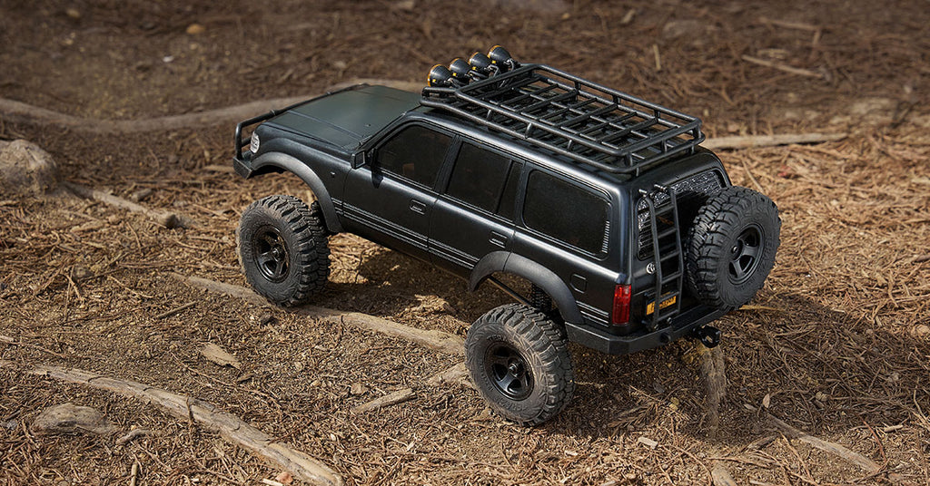 black RC crawler on dirt terrain surface