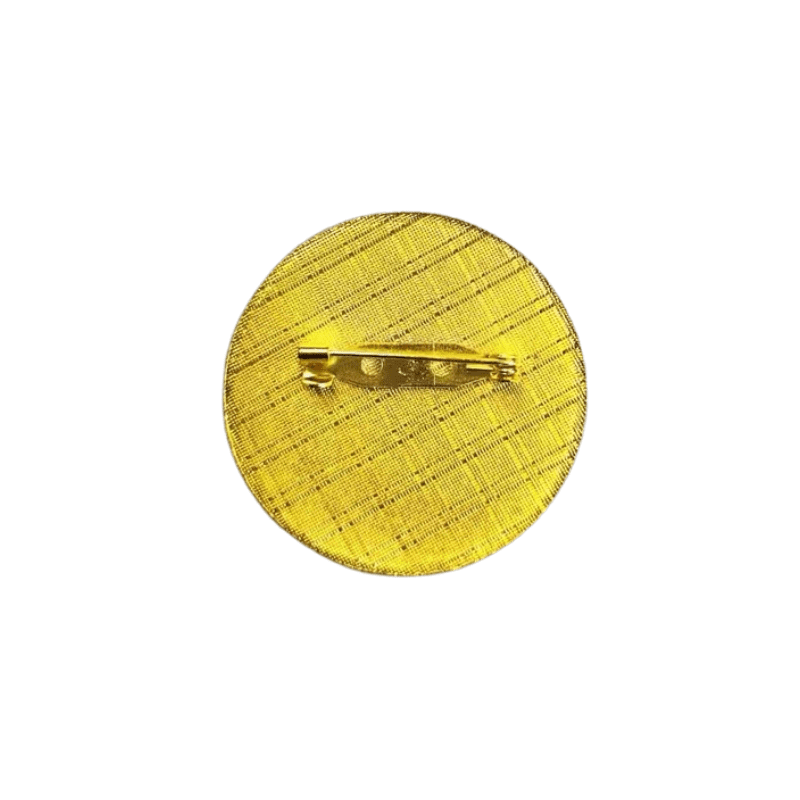 Textured yellow metal pin with safety pin backing for clothing accessories.