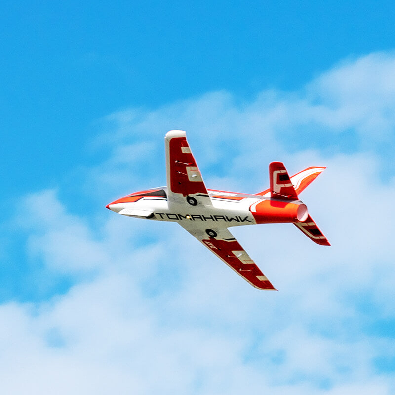 FMS 80mm EDF Jet Futura V3 PNP in flight, red and white livery with 'TOMAHAWK' text.