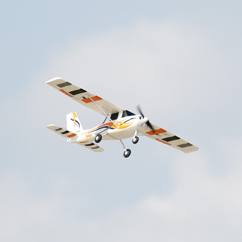 FMS 850mm Ranger airplane in flight with orange and black striped wings and flame graphics.