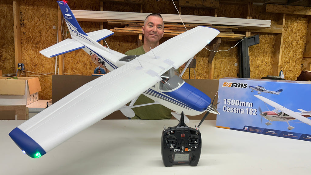 FMS 1500mm Cessna 182 RC plane with DX6e controller displayed in workshop