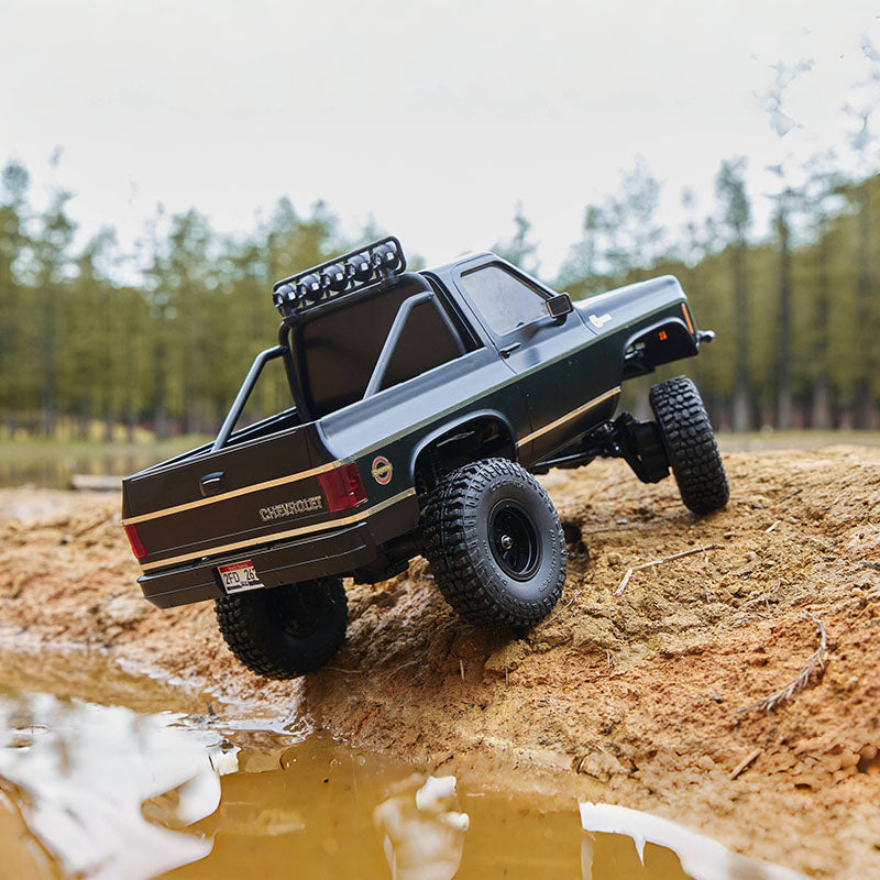 RC Chevrolet truck climbing muddy dirt slope