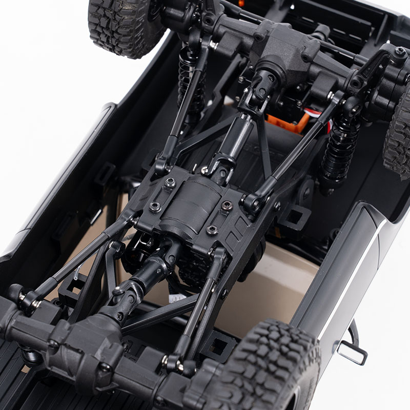 Detailed close-up of an RC crawler's undercarriage and drivetrain components.