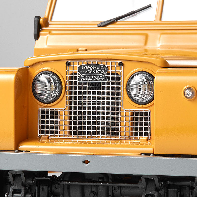 FMS 1:12 Land Rover Series II RTR, yellow, front grille with Land Rover logo and "Four Wheel Drive Station Wagon" text.