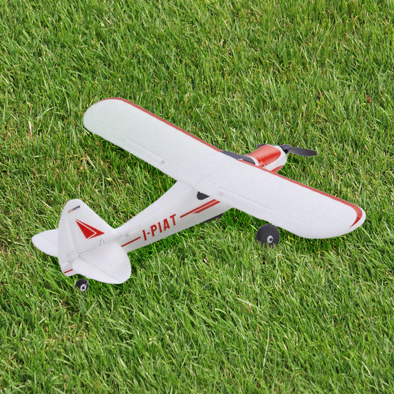 FMS 500mm PA-18 Super Cub RC plane, white with red accents, on grass.