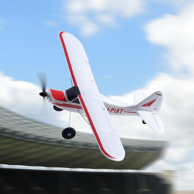 FMS 500mm PA-18 Super Cub RC plane in flight, white with red trim and "-PIAT" text.