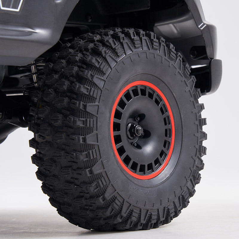 FMS 1:10 Canyon RS off-road RC car wheel with aggressive tread tire and red-accented black rim.