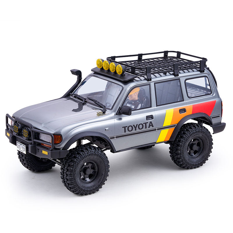 FMS 1:10 LC80 Toyota Land Cruiser 80 RS RC crawler in silver with yellow stripe, roof rack, and off-road tires.