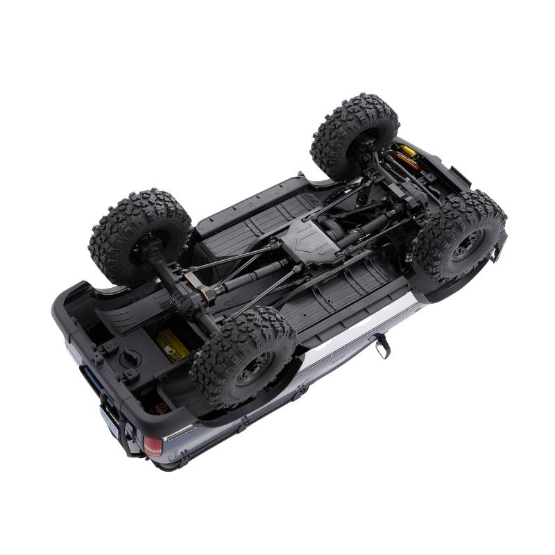 FMS FCX10 PRO LC80 RS V2 underside view: chassis, drivetrain, and large off-road tires.