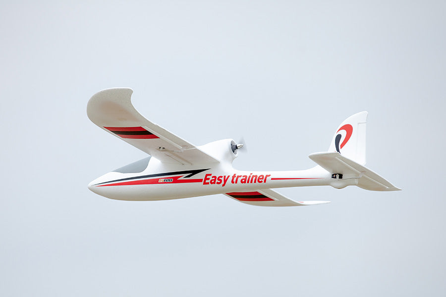 FMS 1280mm Easy Trainer RC airplane in flight with red and black trim, ideal for beginners.