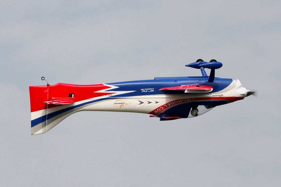 FMS 1400mm F3A Olympus PNP aerobatic RC airplane in flight, featuring red, white, and blue livery and FMSMODEL.COM branding.
