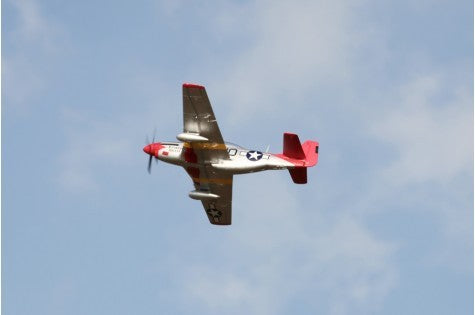 FMS 1450mm P-51D Red Tail V8 PNP RC airplane in flight against a blue sky with white clouds.