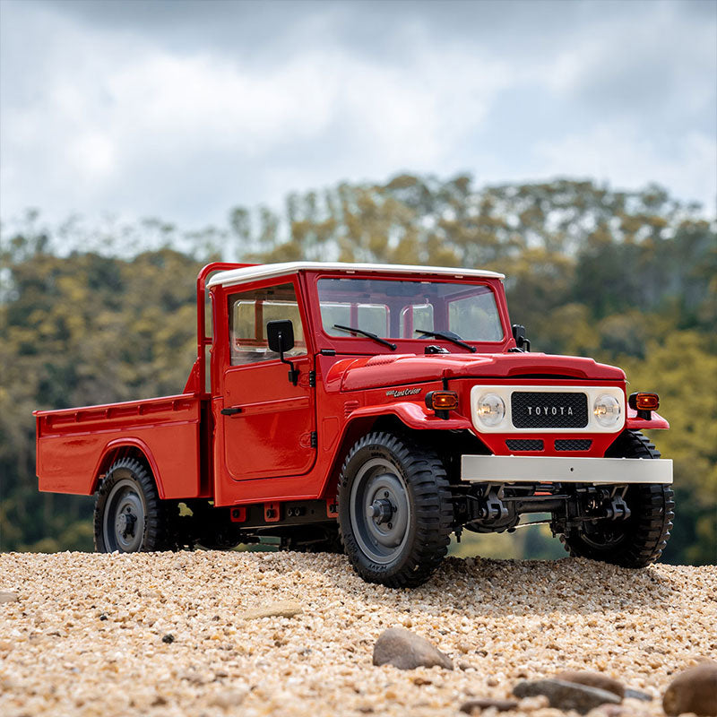 FMS 1:12 scale red Toyota FJ45 pickup truck RTR with white roof, detailed grille and off-road tires on gravel