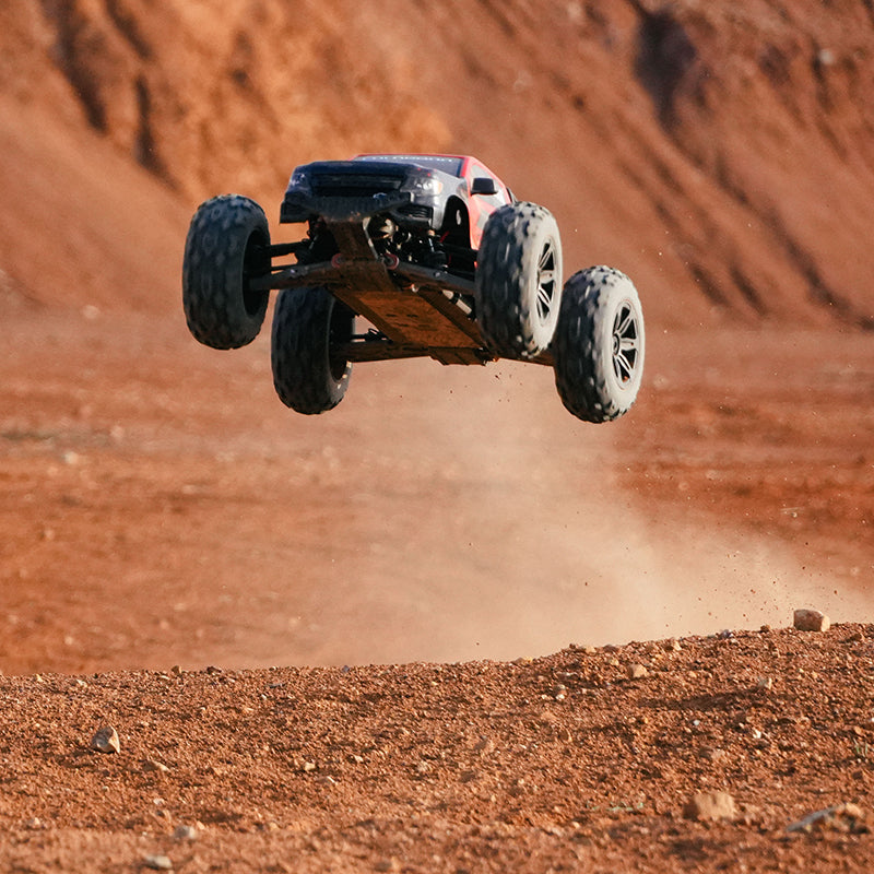 FMS 1:10 Brushless Chevrolet Colorado Basher RS 4WD RC truck airborne over dirt track.