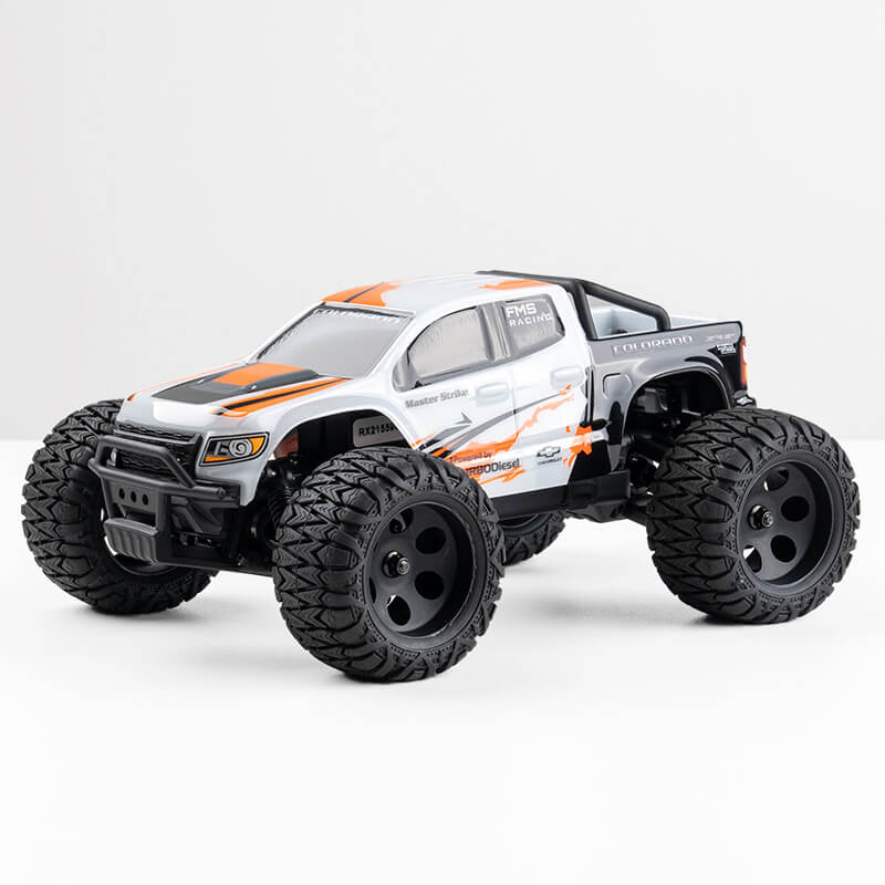 FMS 1:24 FMT24 Chevrolet Colorado Monster Truck RTR in black, white, and orange with large tires