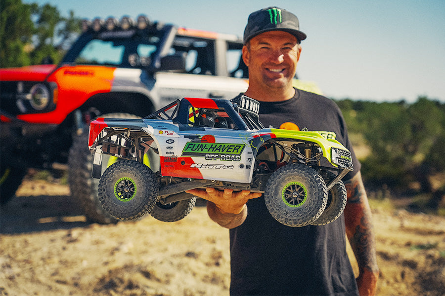 FMS 1:7 Ford Bronco RTR EB Brushless 4WD RS RC truck with vibrant graphics, held by a man. Off-road tires and realistic details.