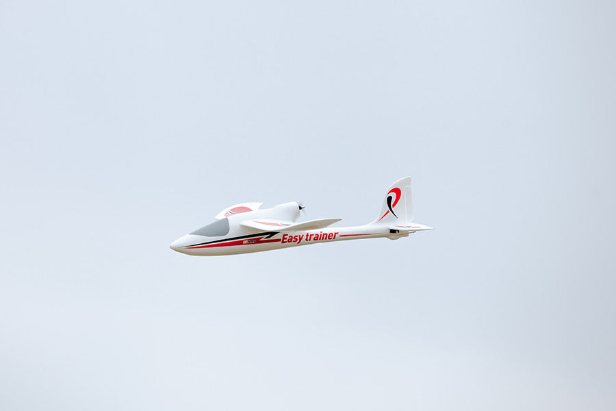 FMS 1280mm Easy Trainer RC airplane in flight, white with red accents and "Easy trainer" text.