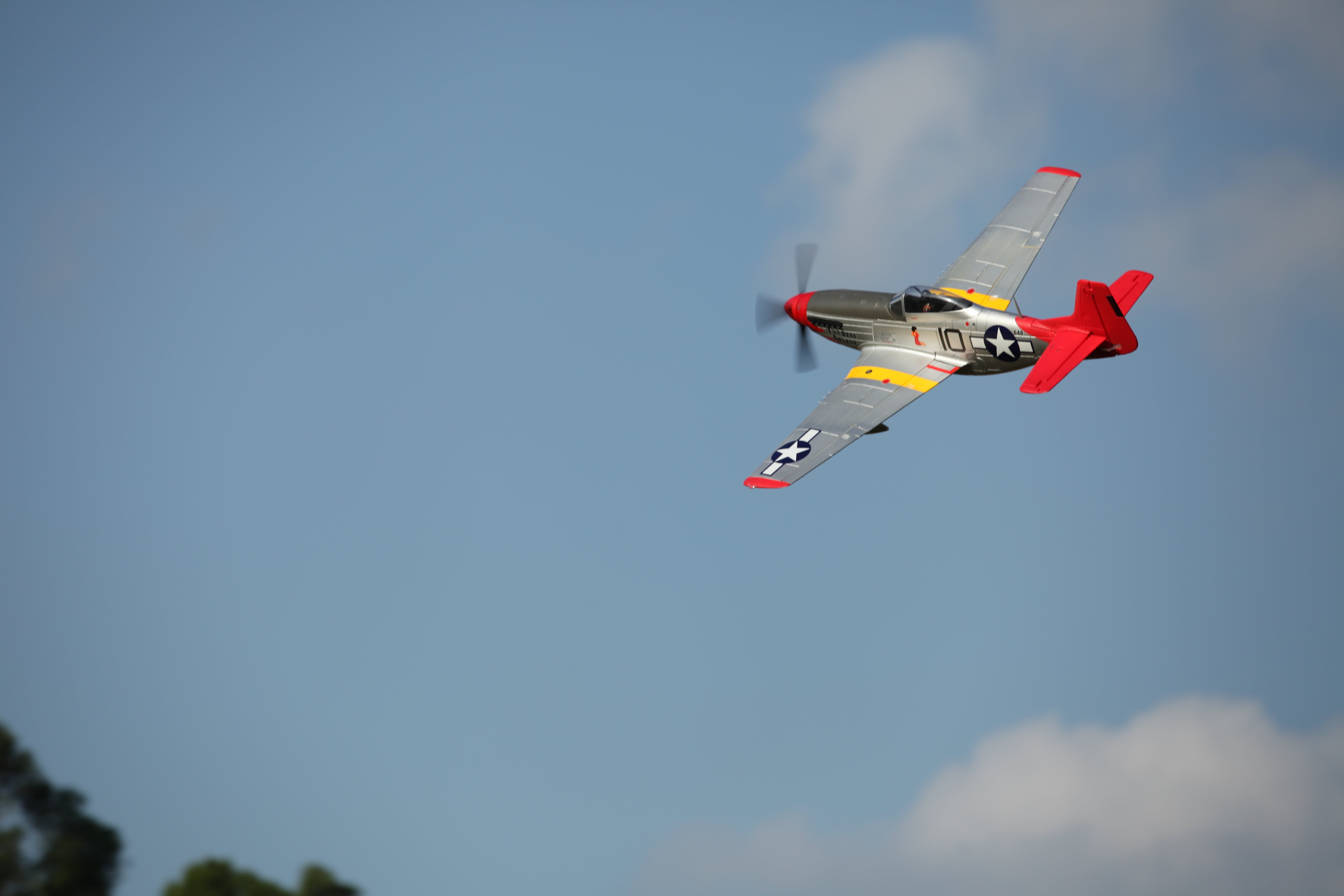 FMS 1450mm P-51D Red Tail V8 PNP RC airplane in flight with detailed markings and a red tail.