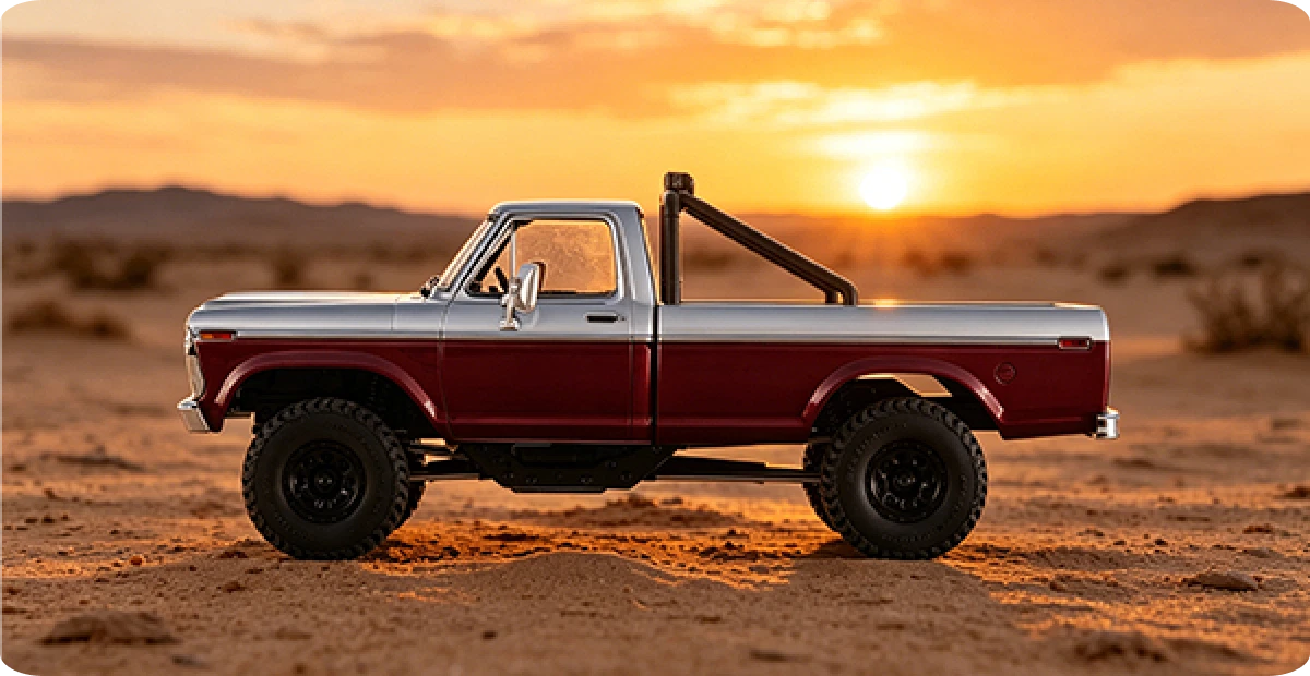 Fmshobby two-tone silver and maroon pickup truck with black roll bar and large off-road tires in desert at sunset